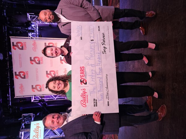 a group of people holding a large check