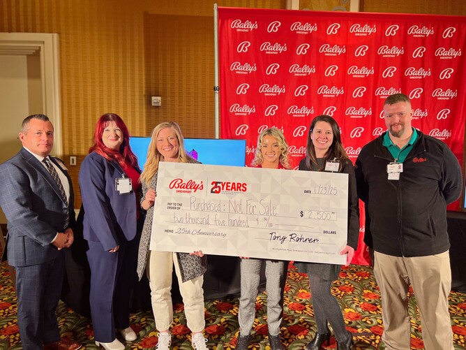 a group of people holding a large check