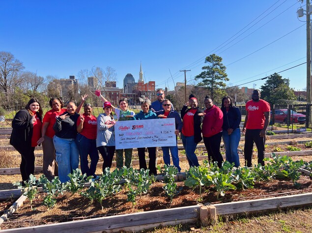 group of people with a check in front of urban farm