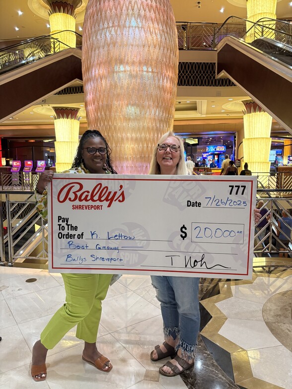 two women holding a large check